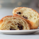 A cross-section of a chocolatine reveals its layers and chocolate.